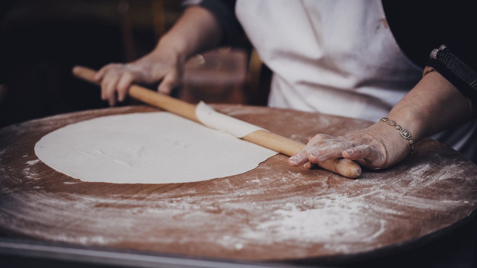 A woman making gözleme on a griddle