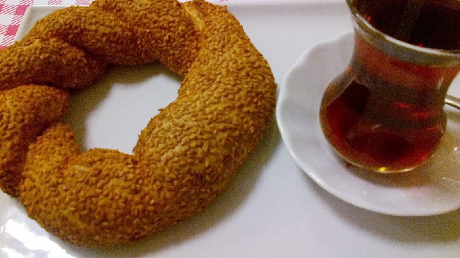Glass of tea beside a sesame simit ring