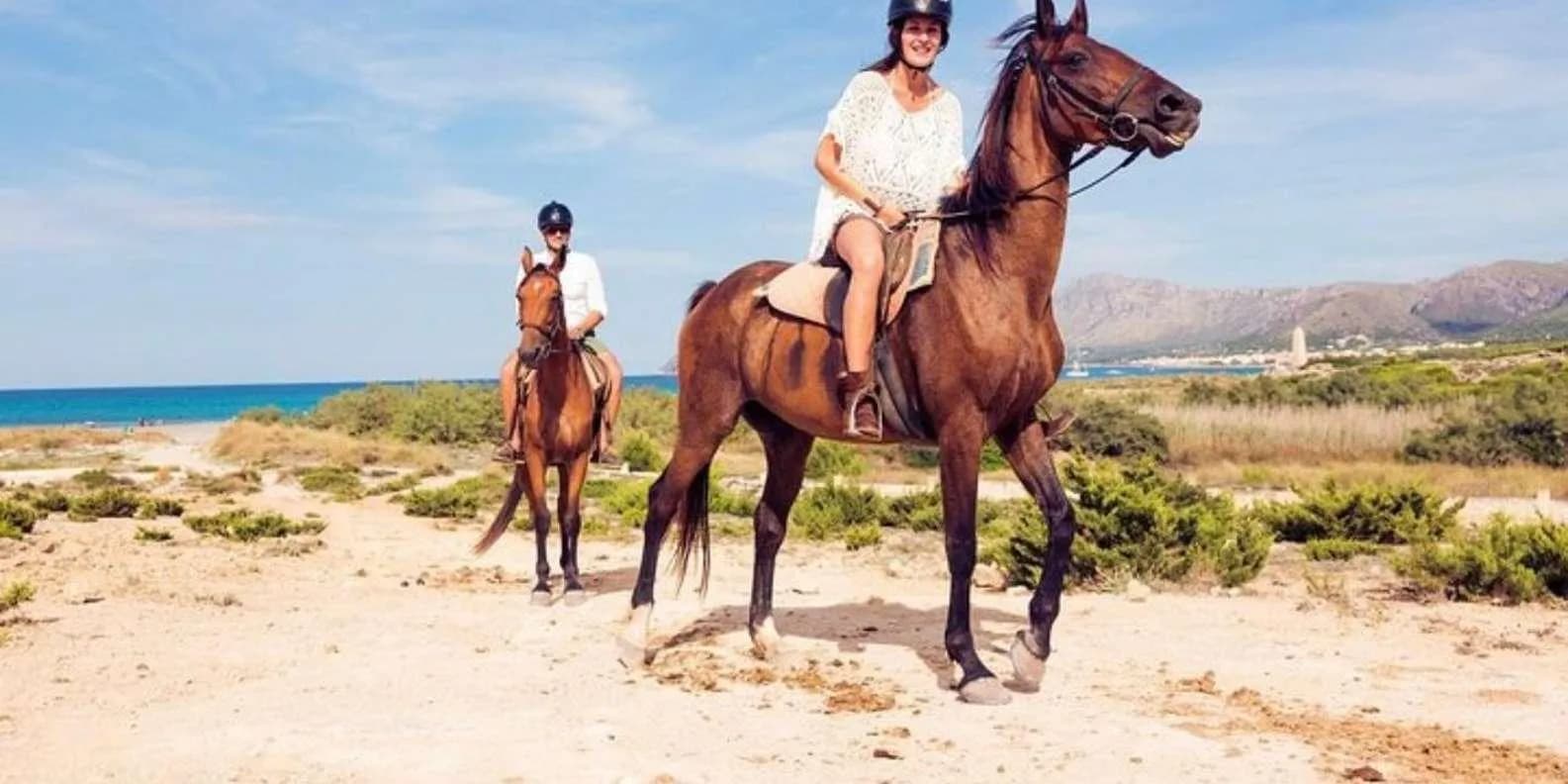 A group of horseback riders following a guide on a mountain path with scenic views of Alanya