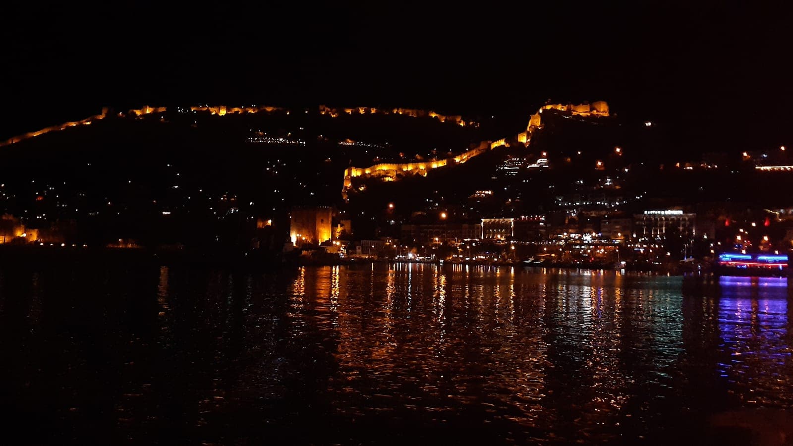 Alanya harbour and the castle walls illuminated at night