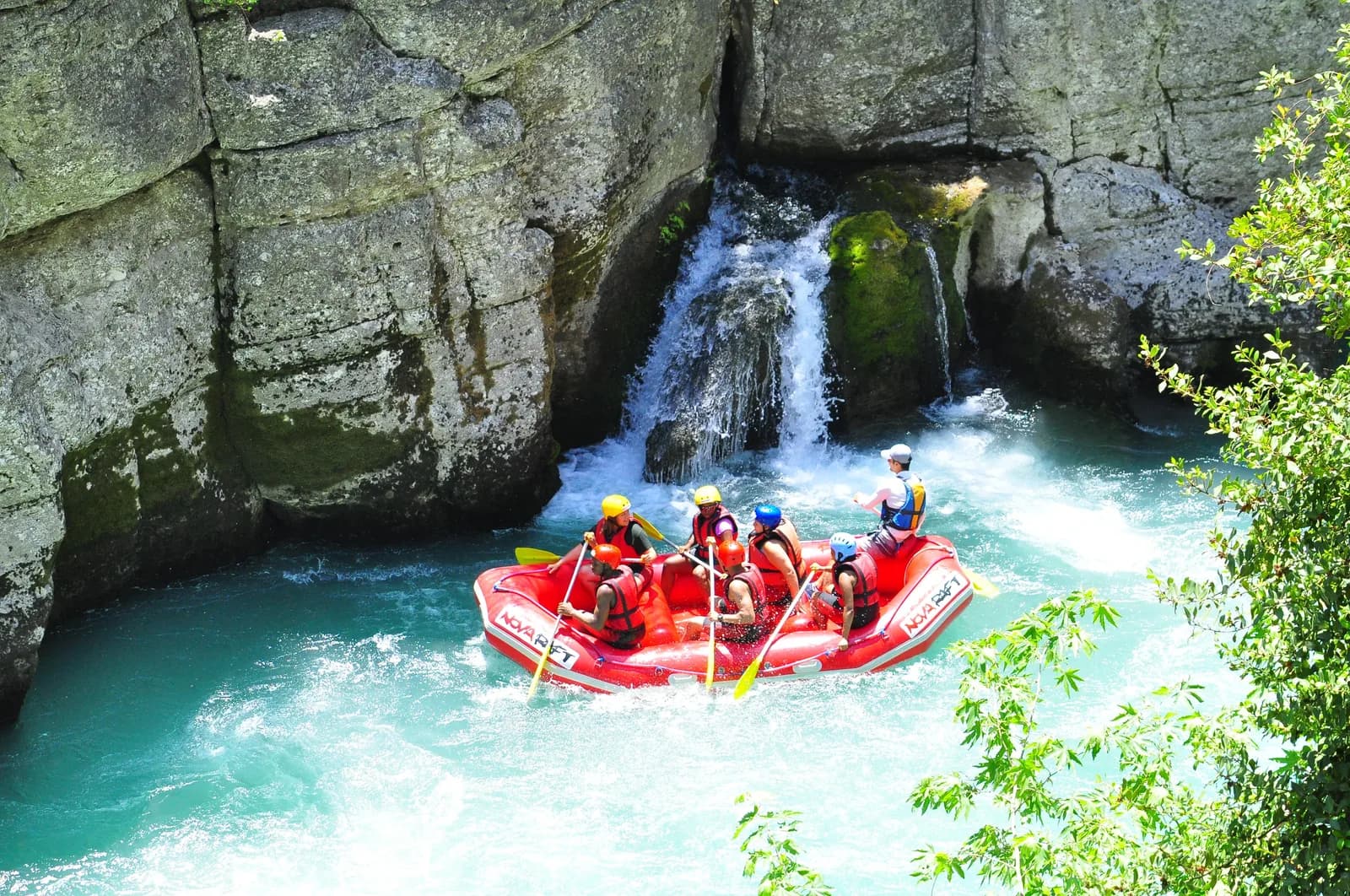 Rafts lined up along the rocky banks of the Köprüçay River surrounded by canyon walls